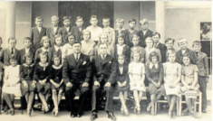Žáci stojí před&nbsp;novou školou, která byla postavena roku 1936